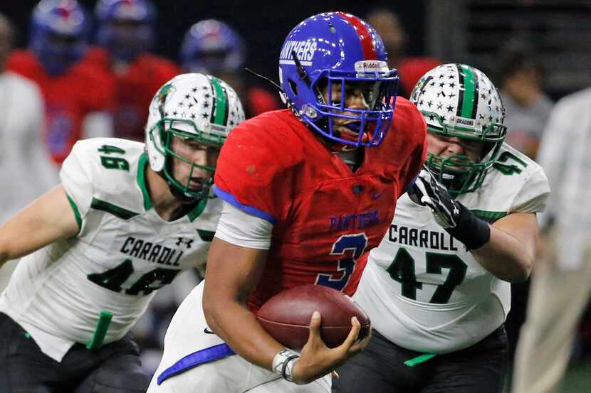 Duncanville quarterback Ja'Quinden Jackson runs for yardage past Carroll defenders Thomas...