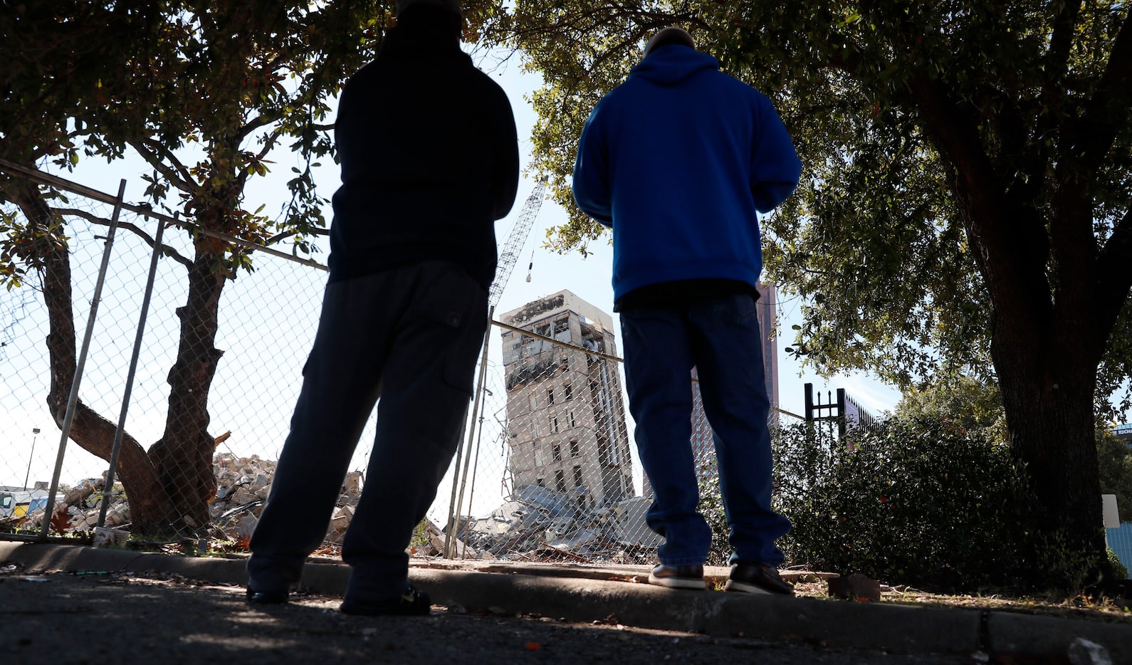 People gather to watch the demolition of the so called "Leaning Tower of Dallas" as a...