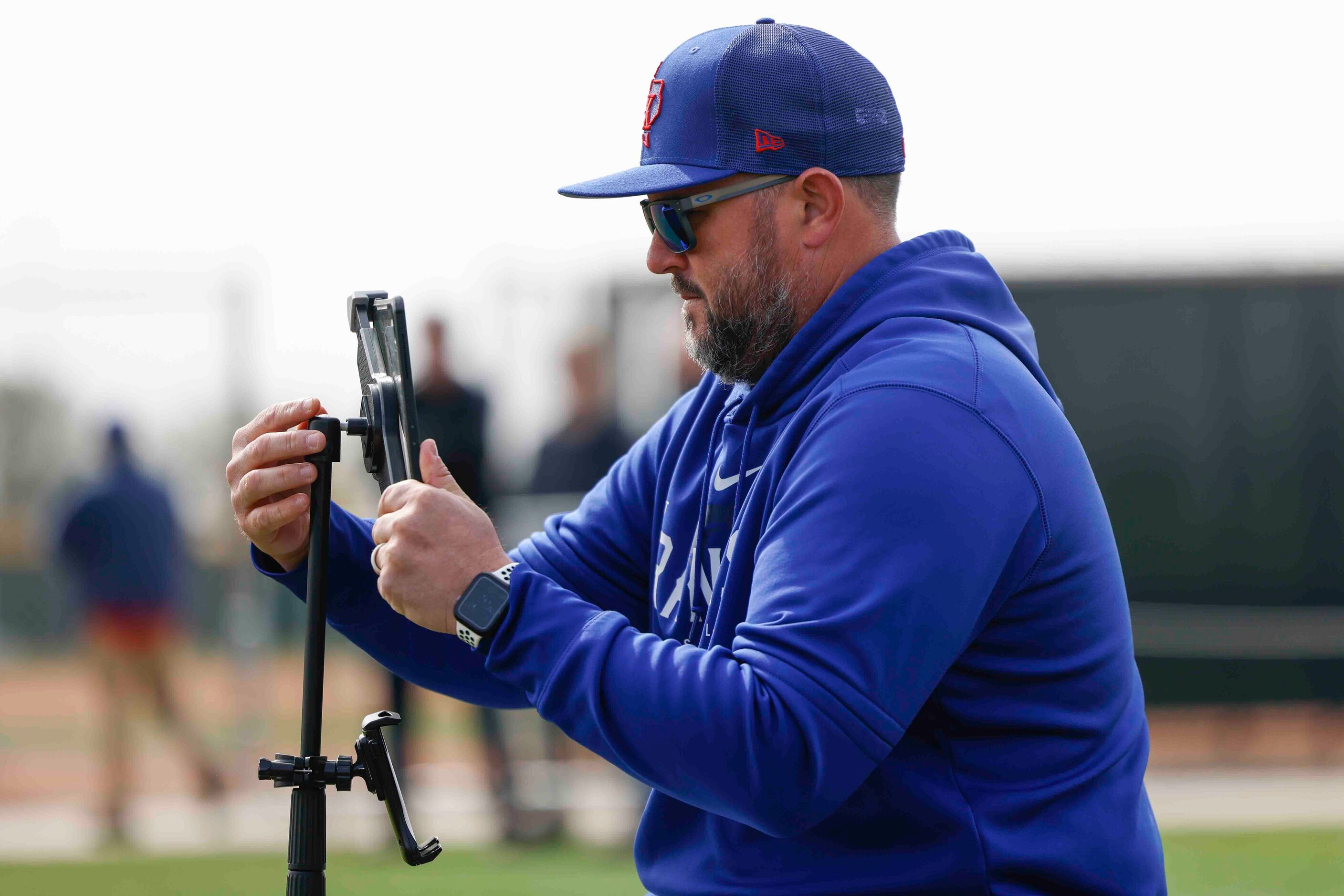 Texas Rangers catching coach Bobby Wilson adjusts the tablet for recording catchers during a...