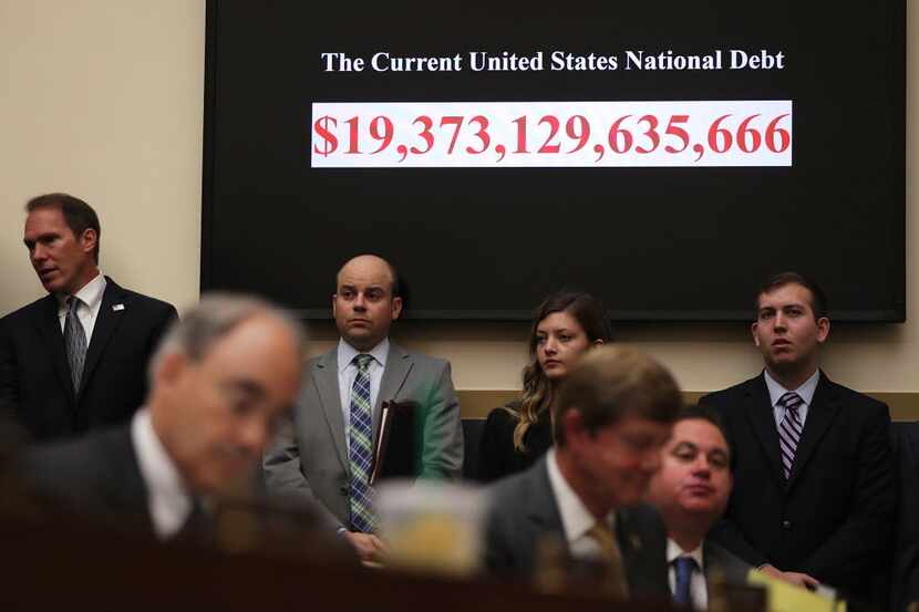 The clock that shows the figure of current national debt looms over a hearing before the...