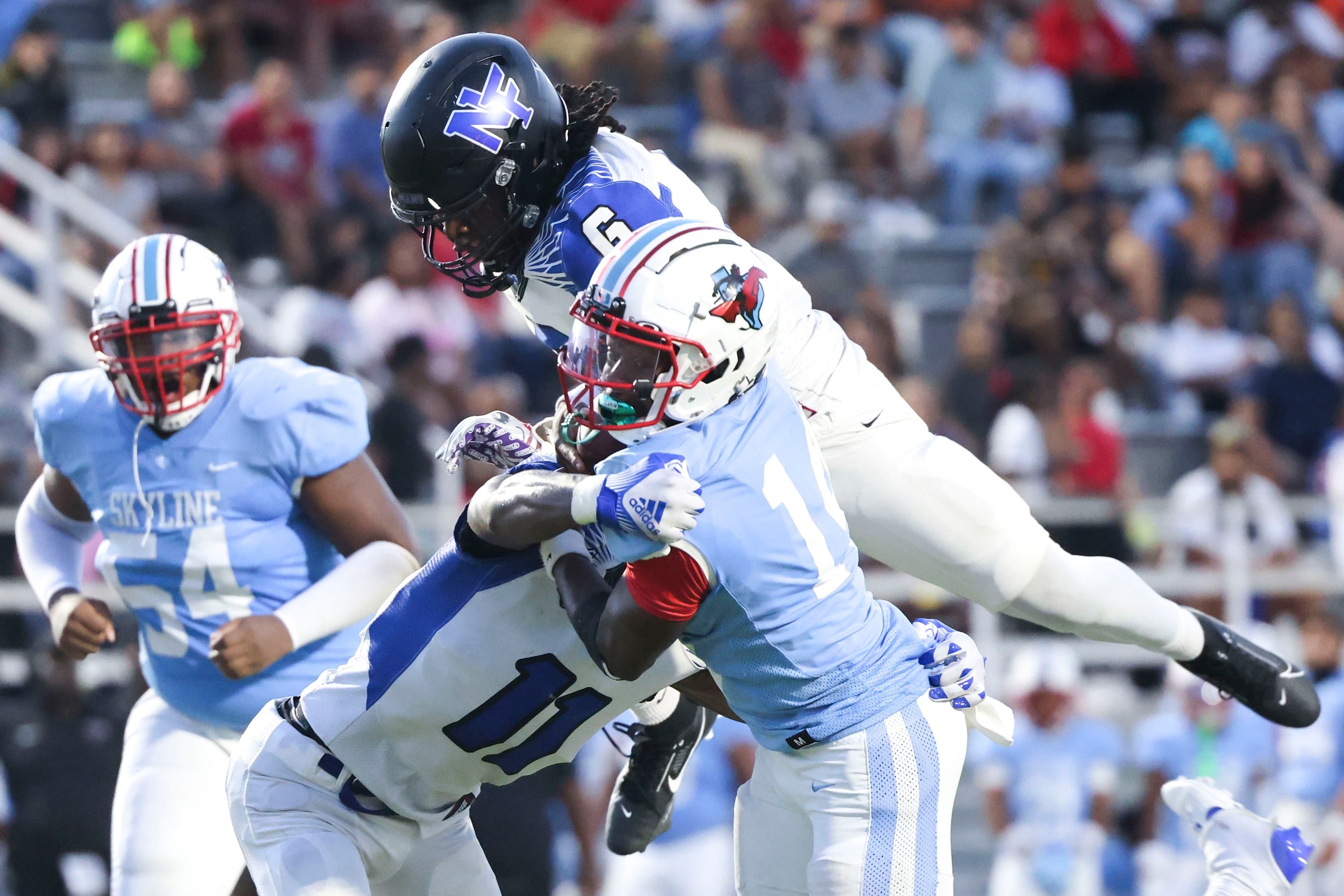 Skyline High’s quarterback Donte Ware (center) is tackled North Forney High’s J’ynv Williams...