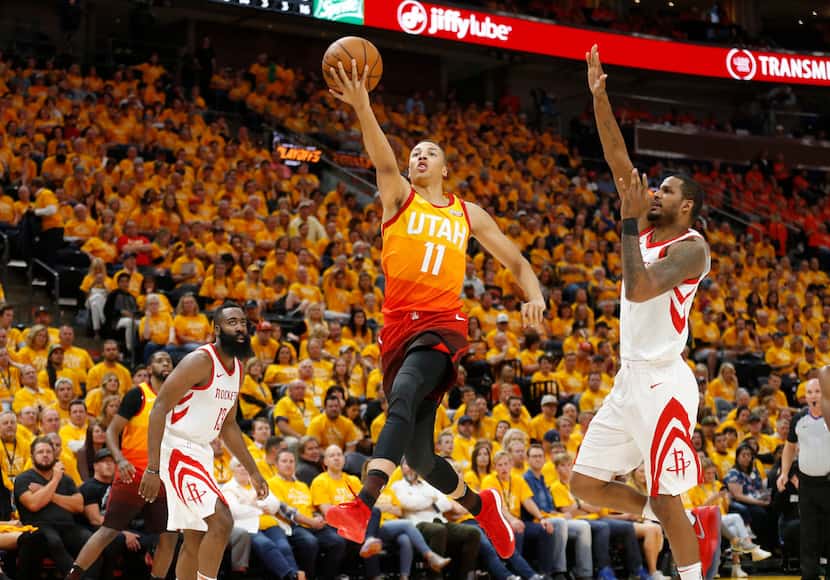Utah Jazz guard Dante Exum (11) lays the ball up as Houston Rockets forward Trevor Ariza,...