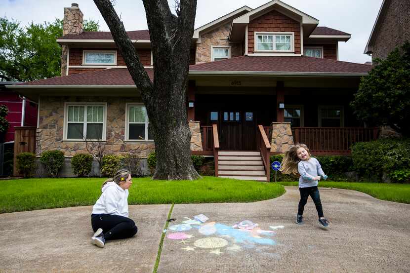 Ashley Szar and her daughter, Emily, 3, draw on their driveway with chalk on March 21, 2020...