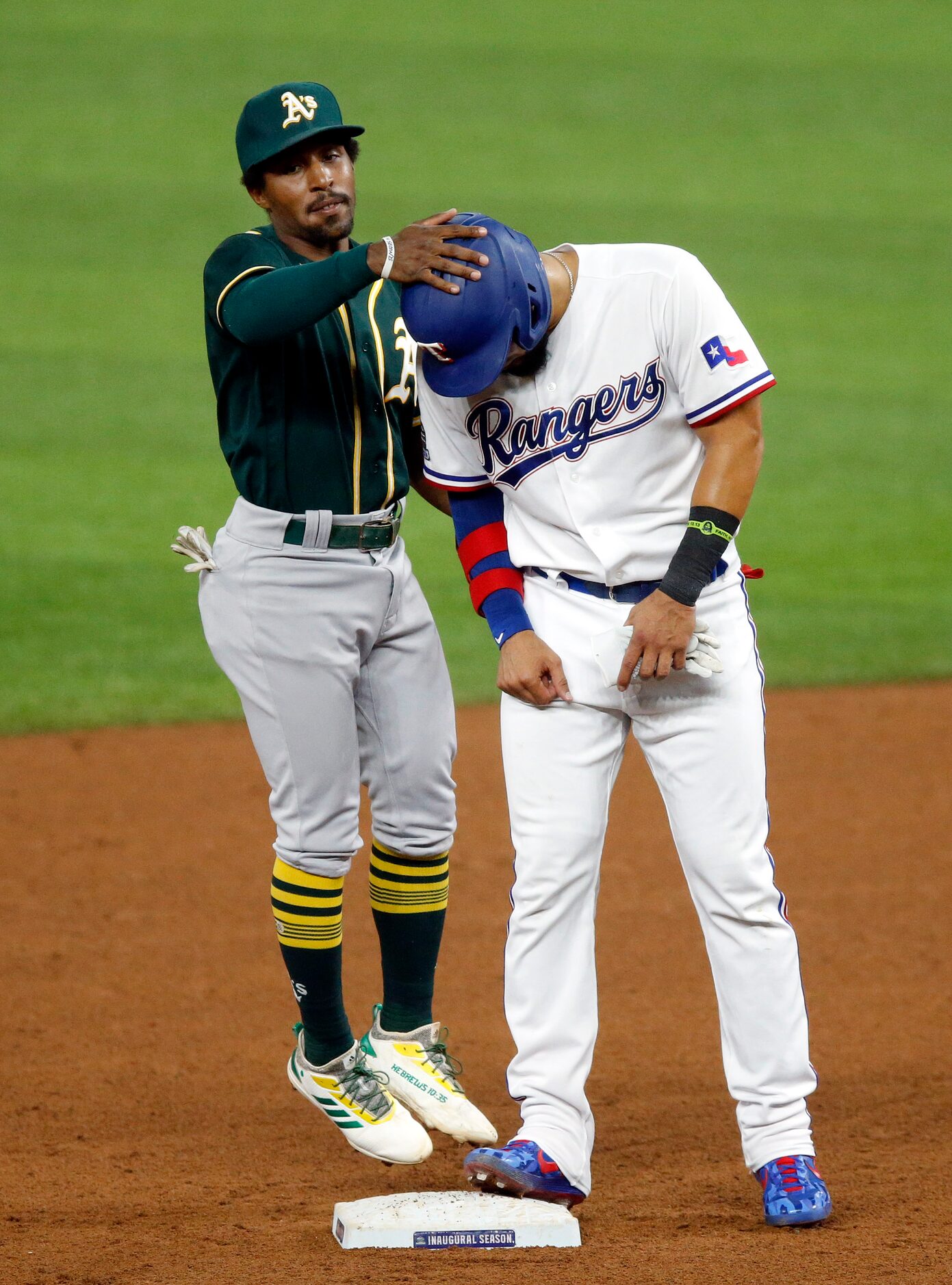 Oakland Athletics second baseman Tony Kemp (5) taps Texas Rangers Robinson Chirinos (61) on...