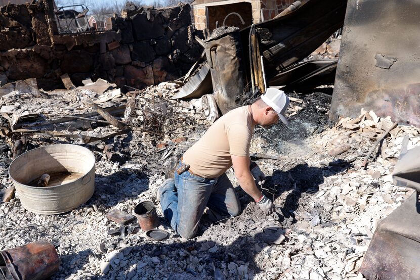 Seth Griffin sorts through the ashes of his mother’s home in Carbon.