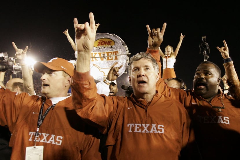 FILE - In this Jan. 4, 2006, file photo, Texas head coach Mack Brown, center, does the...