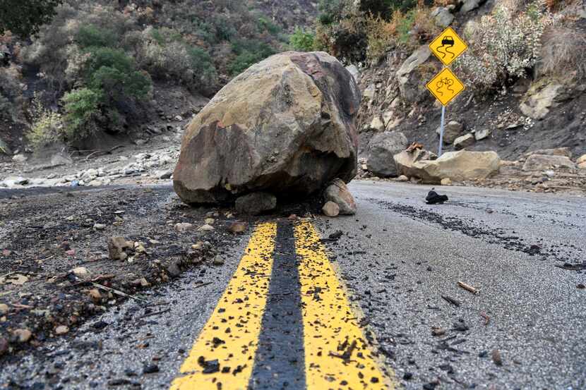 A large boulder sits in the middle of Bella Vista Drive in Montecito, Calif., following the...