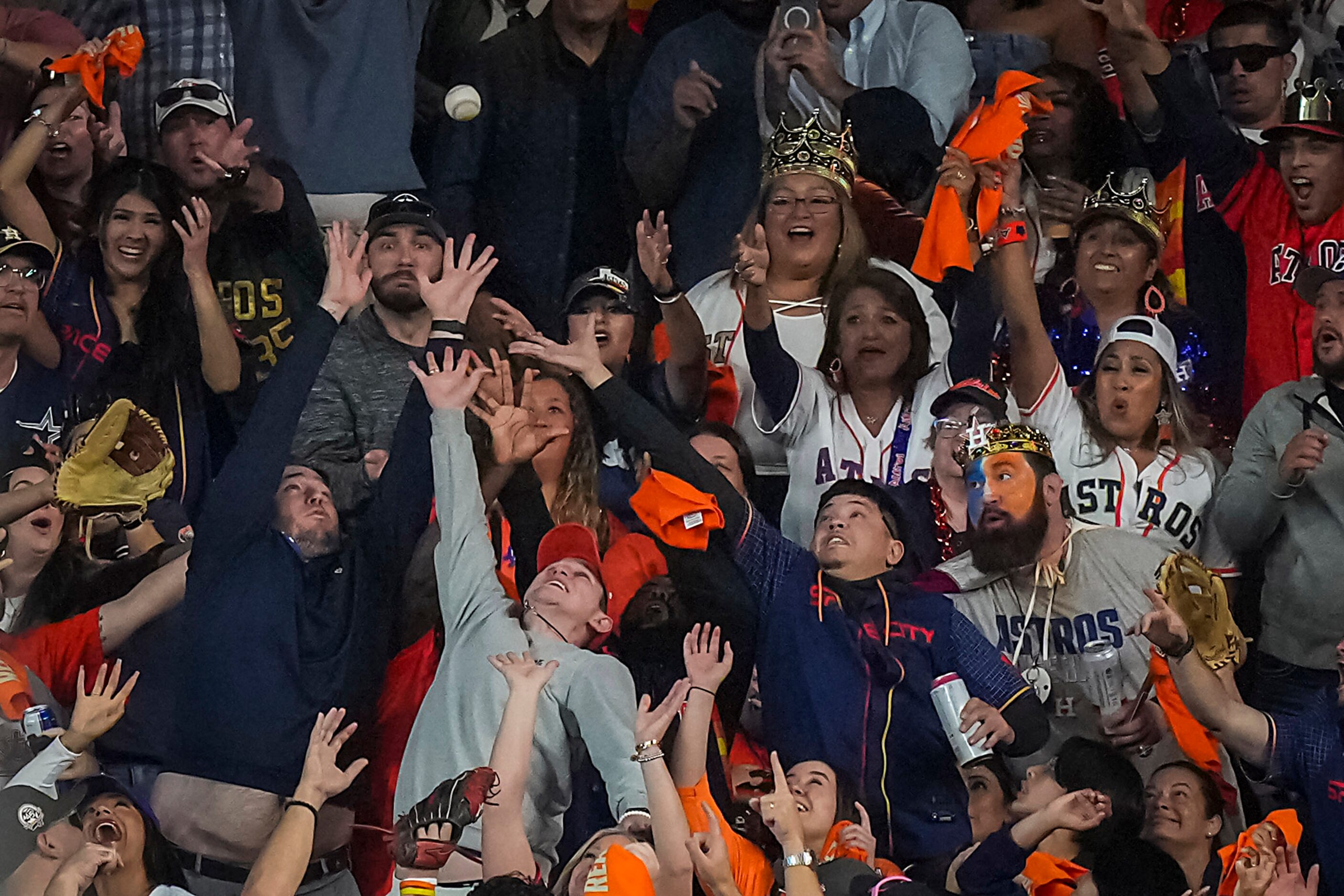 Fans reach for a home run hit by Houston Astros designated hitter Yordan Alvarez during the...