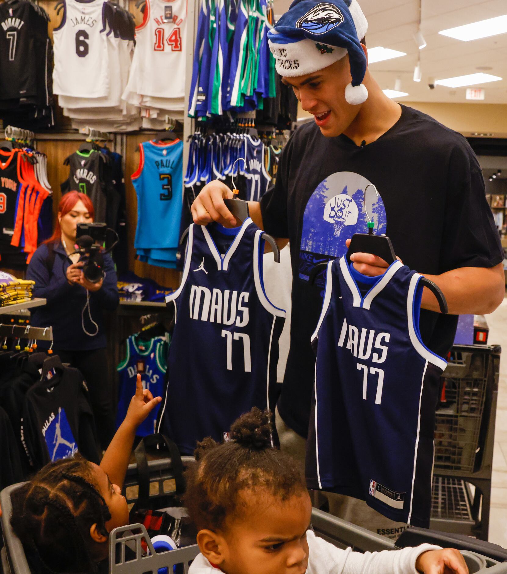 Dash Givens, 3 (left), points to the matching kids’ Dallas Mavericks jerseys held by Dallas...