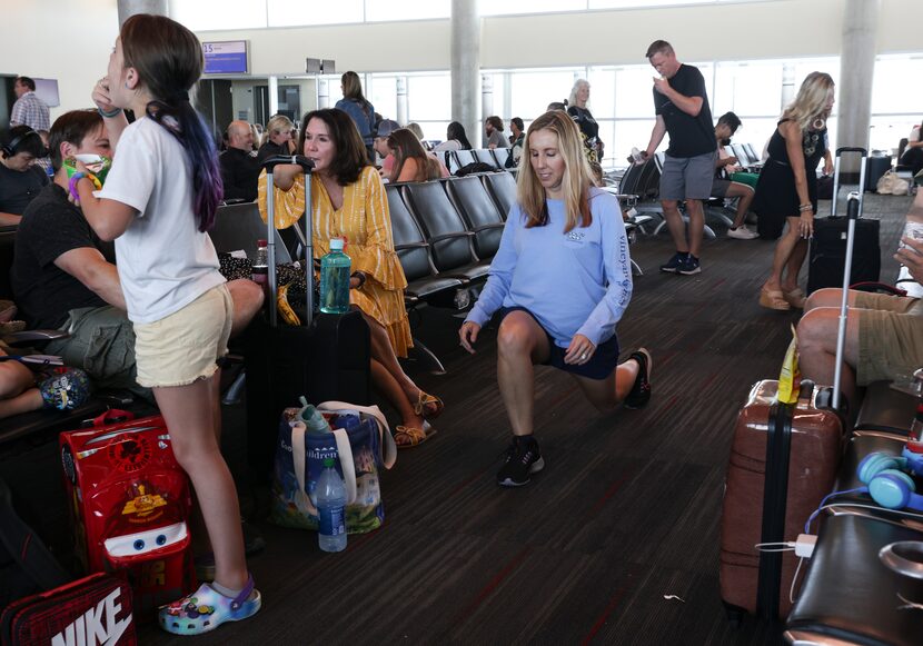 Sarah Roland does lunges while waiting during a four hour flight delay to Long Beach.