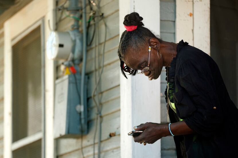 Thelma Jean Williams, 64, checks her phone after listening to a news conference at her...