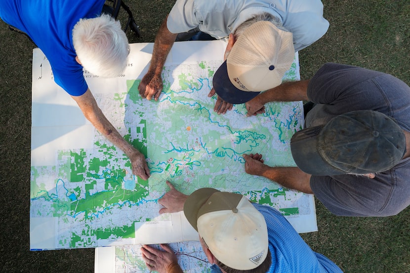 Gary Cheatwood, (top left) and son Gary Cheatwood Jr., (bottom) go over a map the elder...