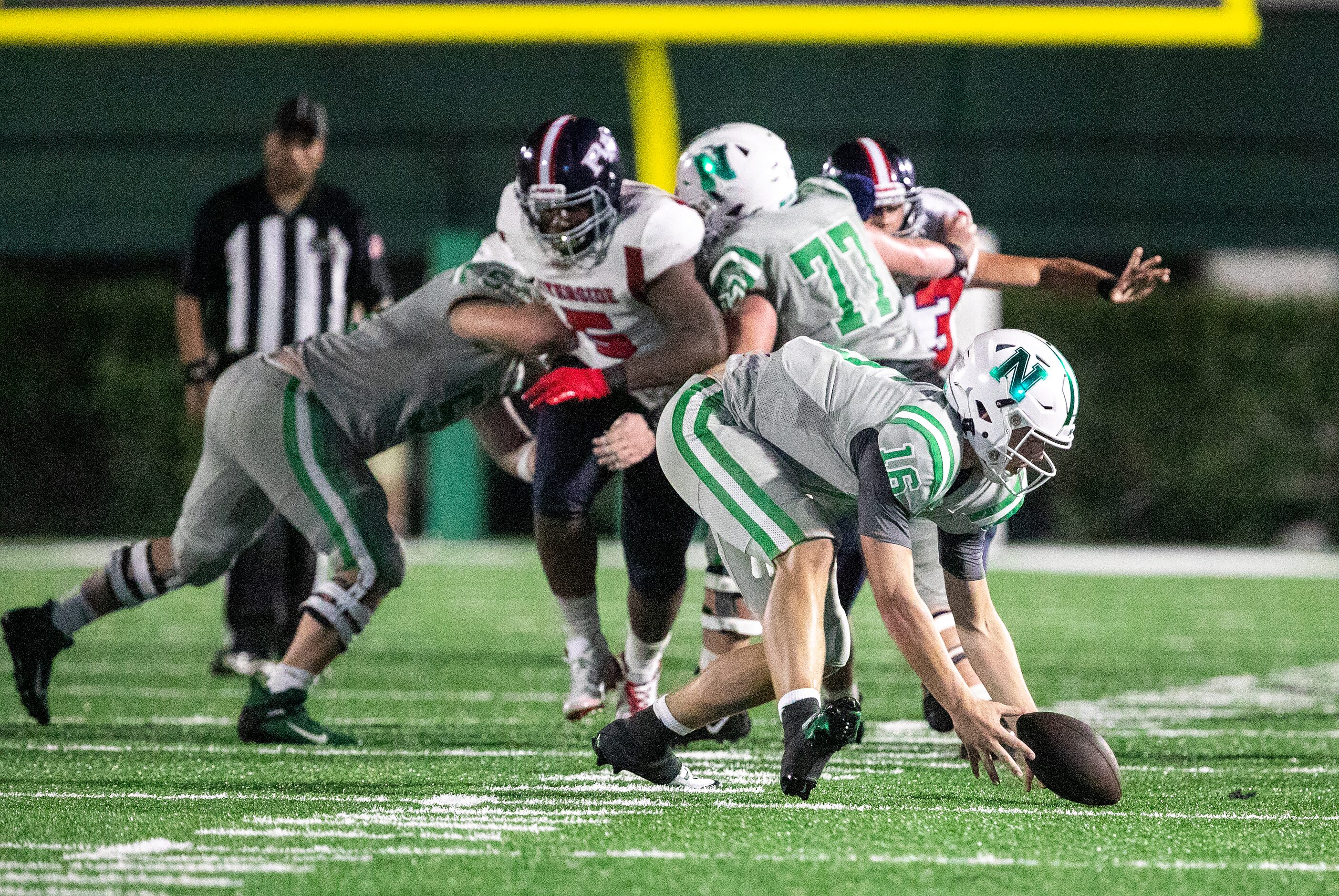 Arch Manning scoops up a low snap and passes for a first down as Newman High School takes on...