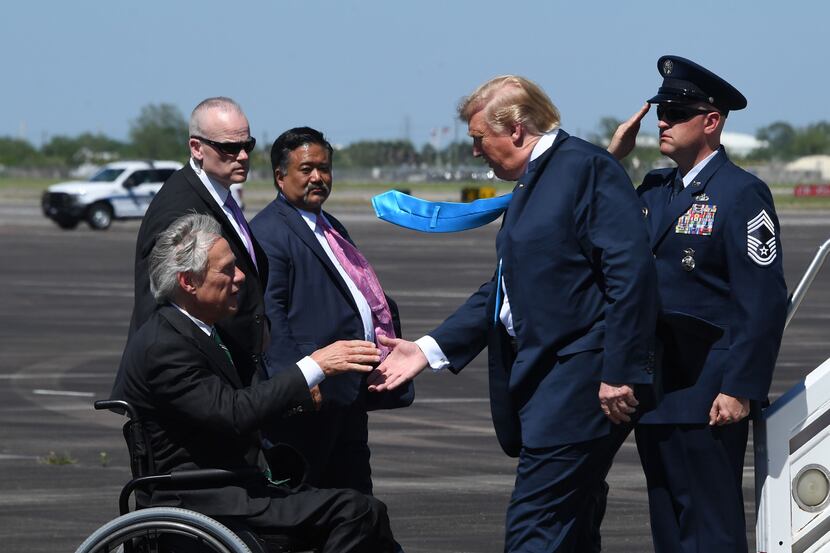 President Donald Trump shake hands with Texas Gov. Greg Abbott as he arrives in Houston,...