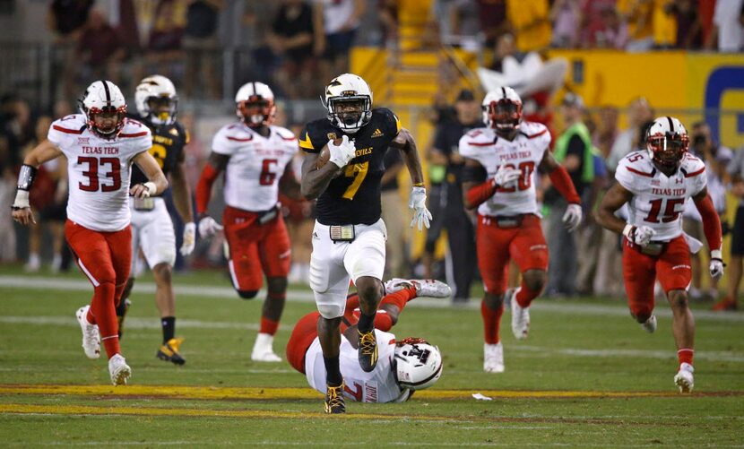 Arizona State's Kalen Ballage (7) runs past Texas Tech defenders Brayden Stringer (33), Kris...