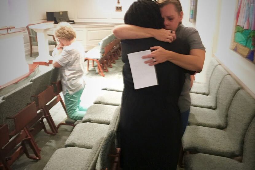 Arlene Williams, in black dress, hugs an unidentified woman in the chapel of Baylor...