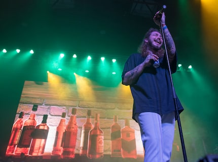 Post Malone holds a beer can while he performs at the Bomb Factory in Deep Ellum.