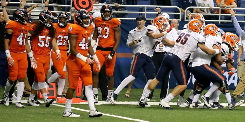 Members of the UTEP celebrate with teammate Warren Redix, far right, after he caught the...
