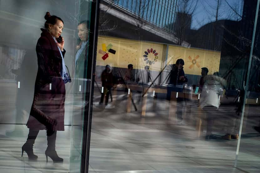A woman uses her mobile phone at a mall in Beijing on January 14.  (Photo by NOEL CELIS /...