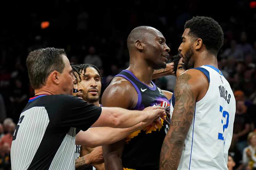 Referee David Guthrie (16) tries to separate Phoenix Suns center Bismack Biyombo and Dallas...