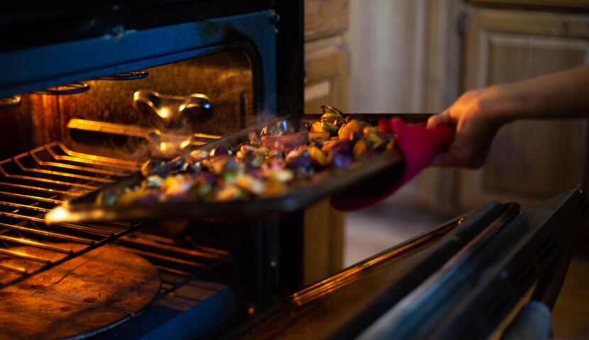 With steam rolling off the top, Jade Chessman removes her roasted vegetables from the oven.