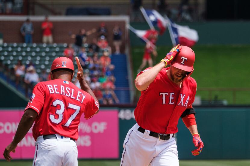 Texas Rangers designated hitter Hunter Pence celebrates with third base coach Tony Beasley...