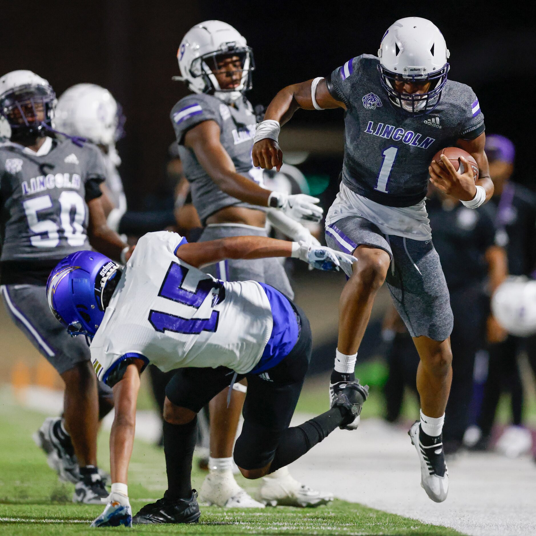 Lincoln running back Talan Beachum (1) jumps over Conrad defensive back Raymond Udoh (15)...