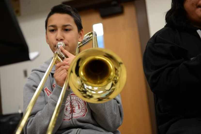 
Eighth-grader Bryan Flores plays the trombone during his advanced band class. Prior to band...