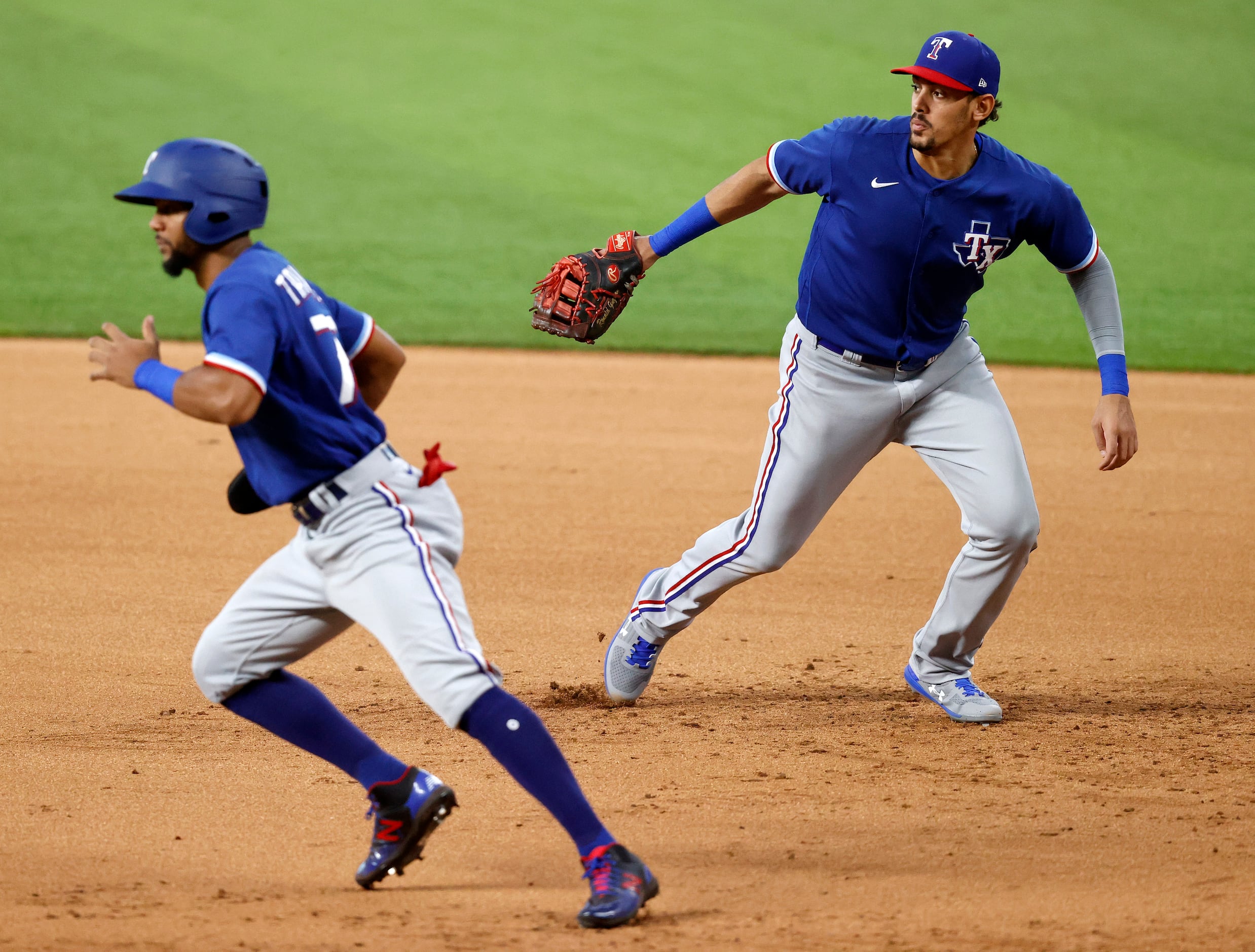 Texas Rangers first baseman Ronald Guzman (right) breaks for the base on an infield hit as...