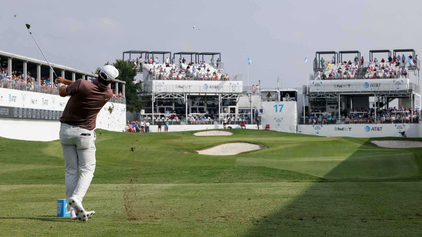 Scottie Scheffler, of the United States, tees off at the 17th hole during the first round of...
