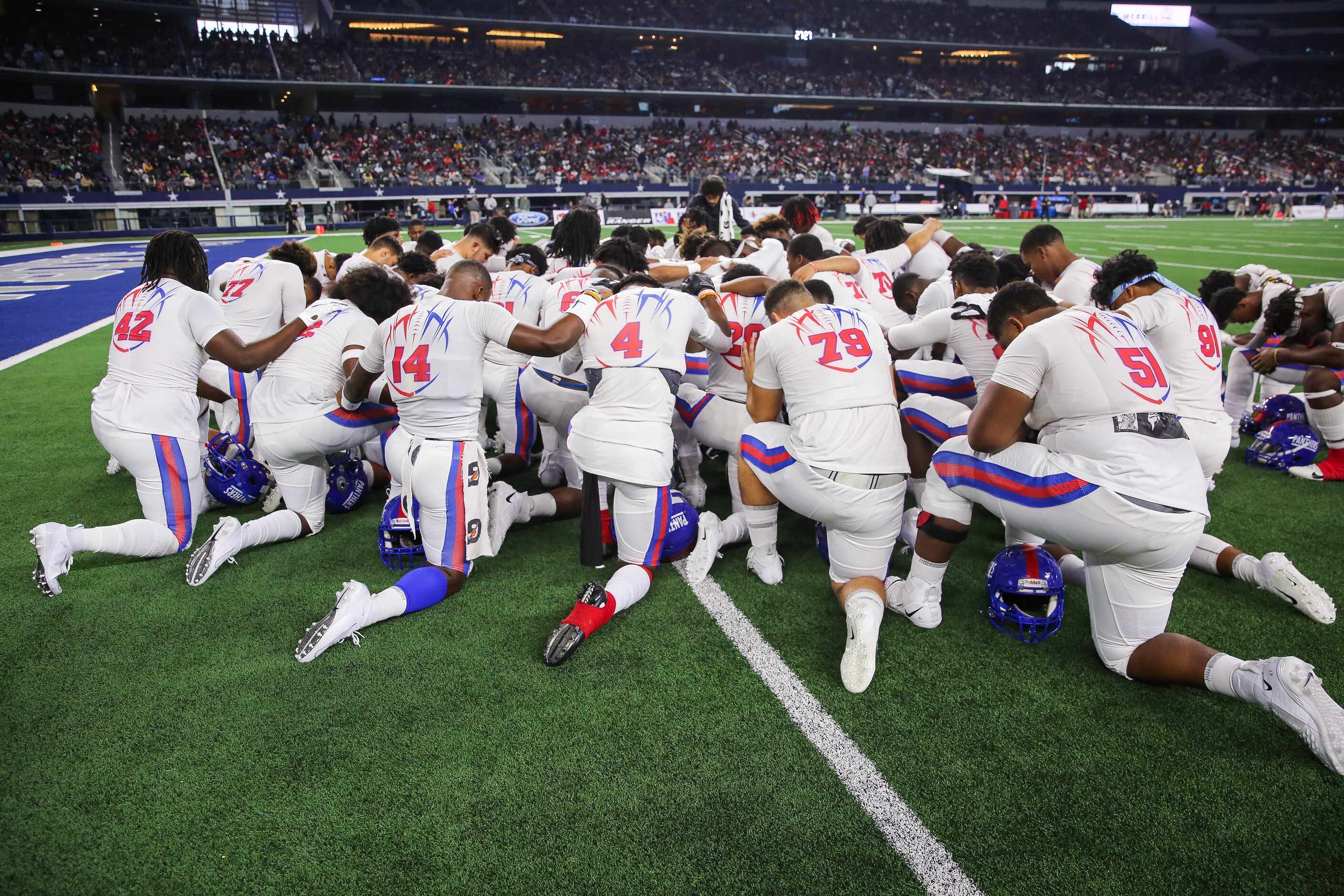 Duncanville players pray before a Class 6A Division I state championship game against Galena...