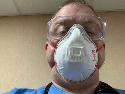 Jim Mullen, in N95 mask and scrubs, before one of his overnight shifts in a hospital...