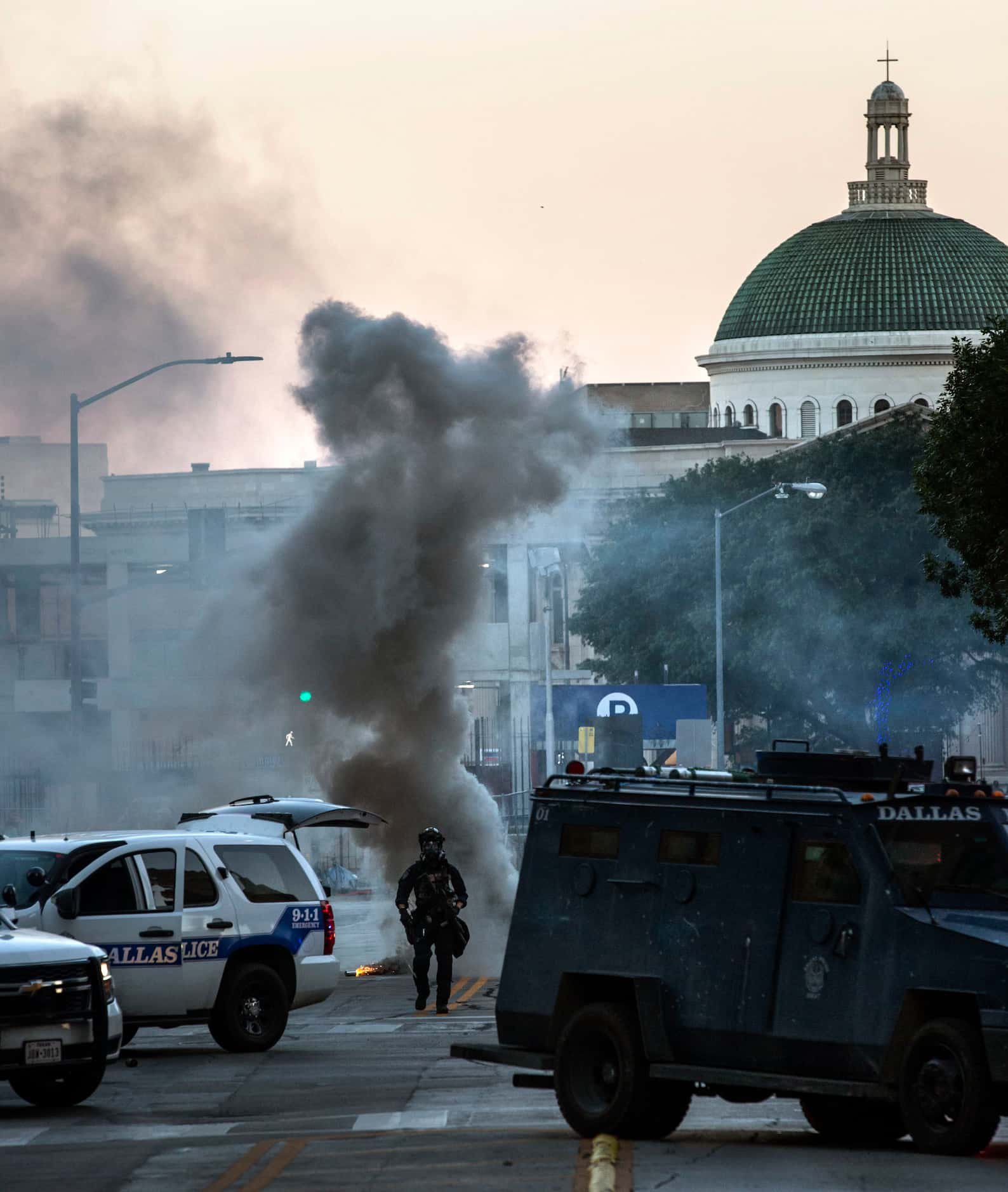 Police detonate smoke bombs while establishing a perimeter in downtown Dallas to disperse a...