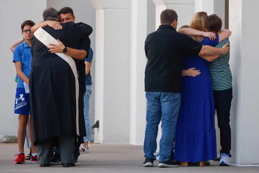 Parishioners embraced each other after a memorial service for Julio Oliveira on Aug. 29 at...