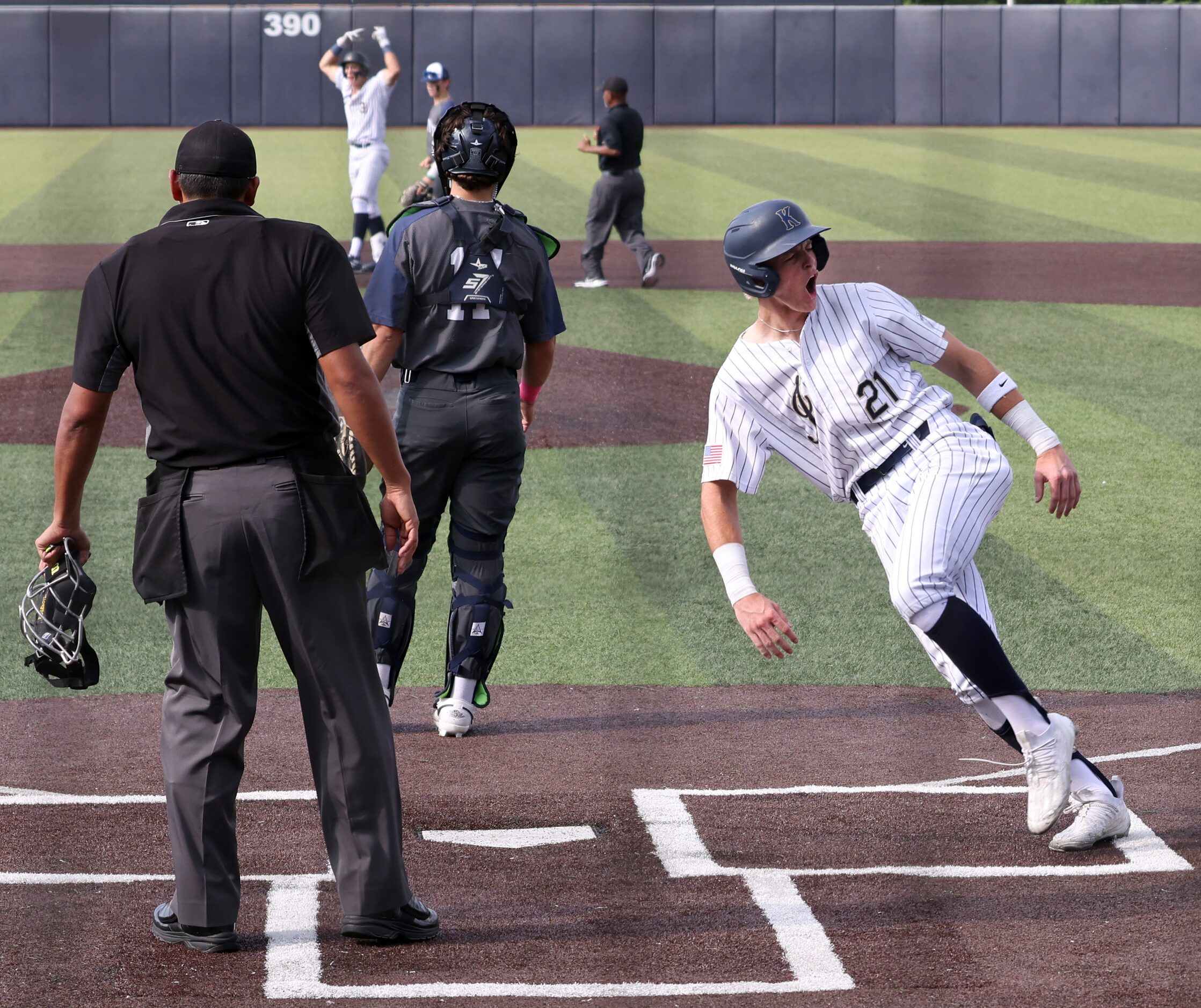 Keller baserunner Cole Koeninger (21) celebrates at home plate after scoring on teammate...