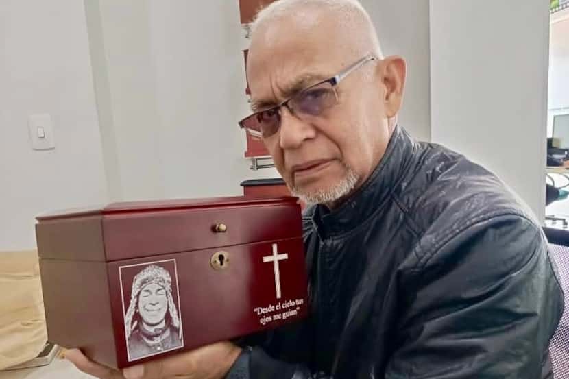 Santos Cumana holds the urn with the ashes of his son, Elio David Cumana Rivas, on August 4,...