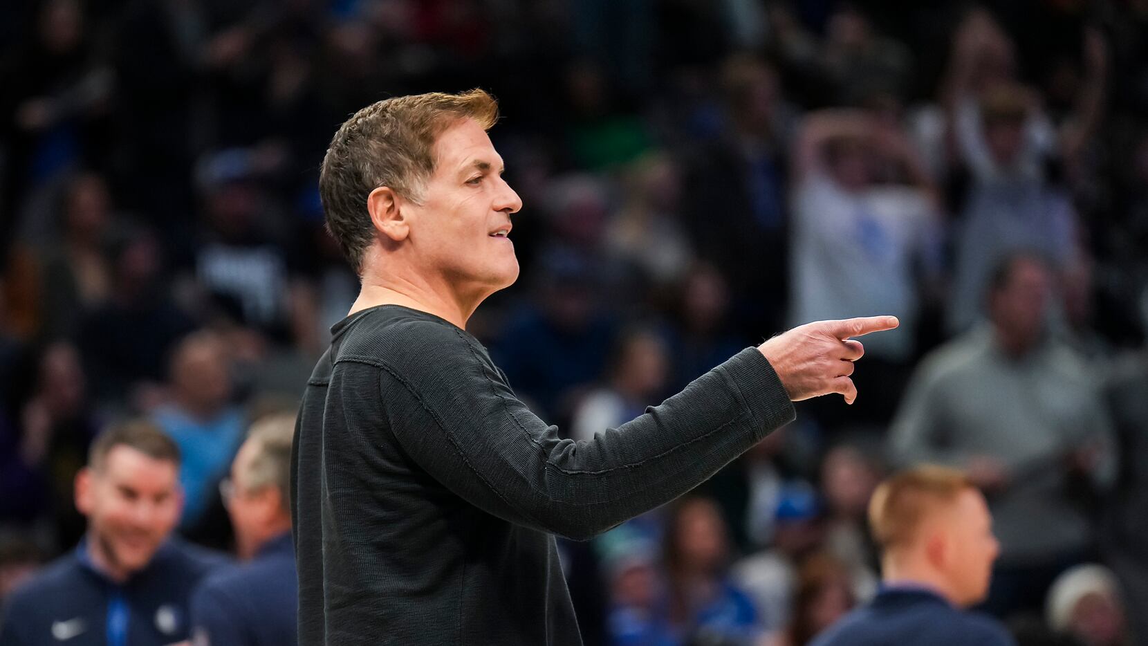 Dallas Mavericks owner Mark Cuban points to the court during a timeout in the second half of...