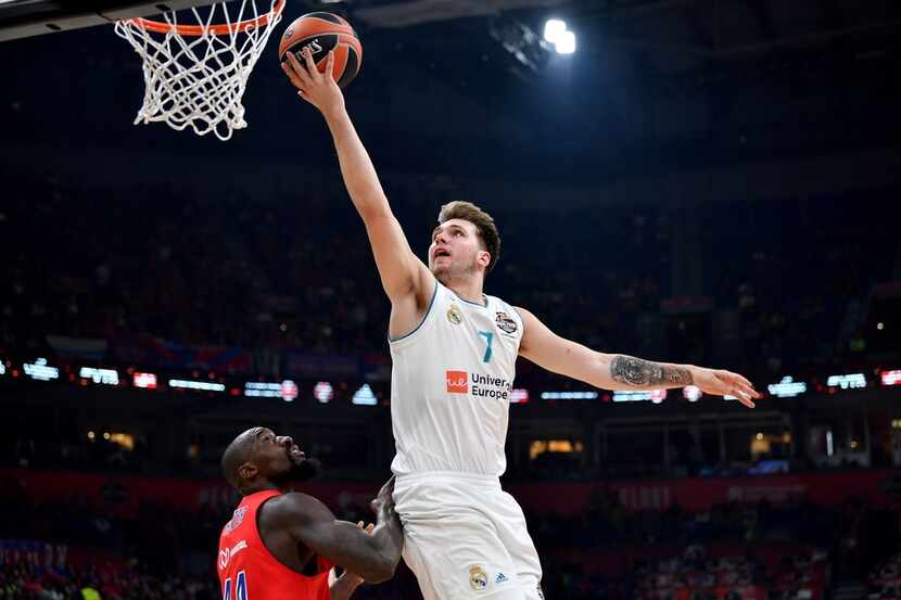 TOPSHOT - Real Madrid's Slovenian Luka Doncic (R) goes for the basket past CSKA's US center...