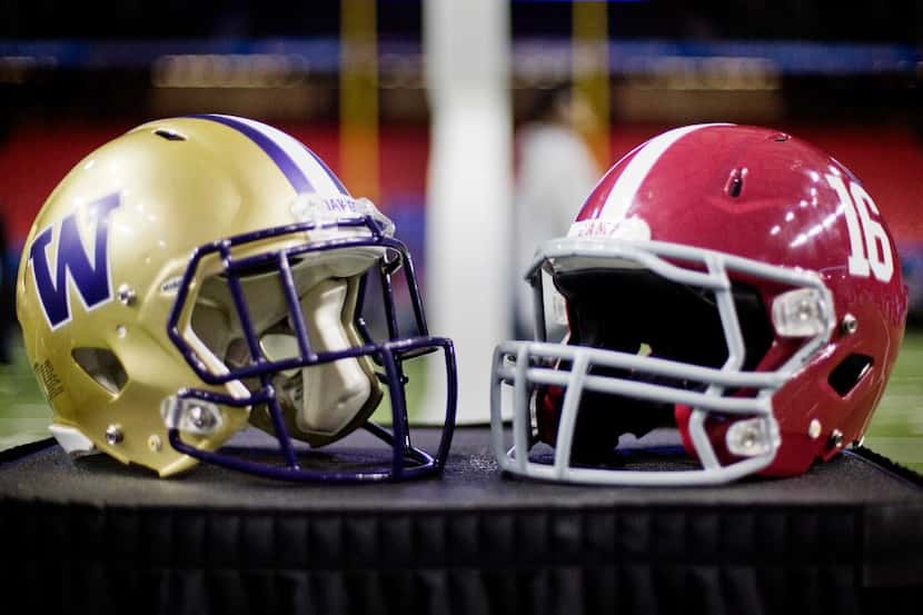 Football helmets from Washington, left, and Alabama are displayed during media day for...
