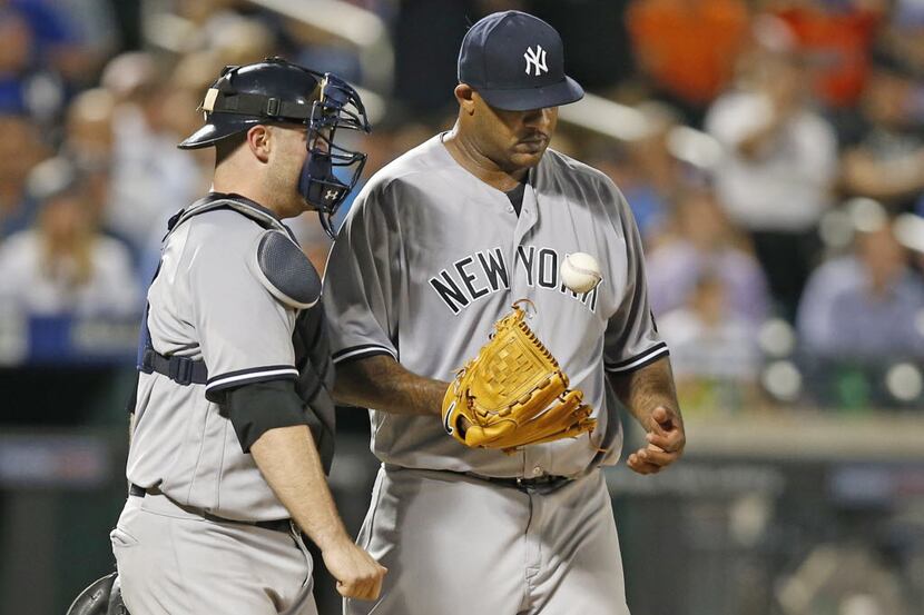 New York Yankees catcher Brian McCann, left, stands on the mound with New York Yankees...