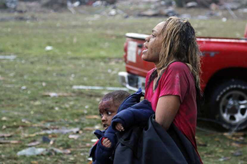 A woman carries an injured child to a triage center near the Plaza Towers Elementary School...