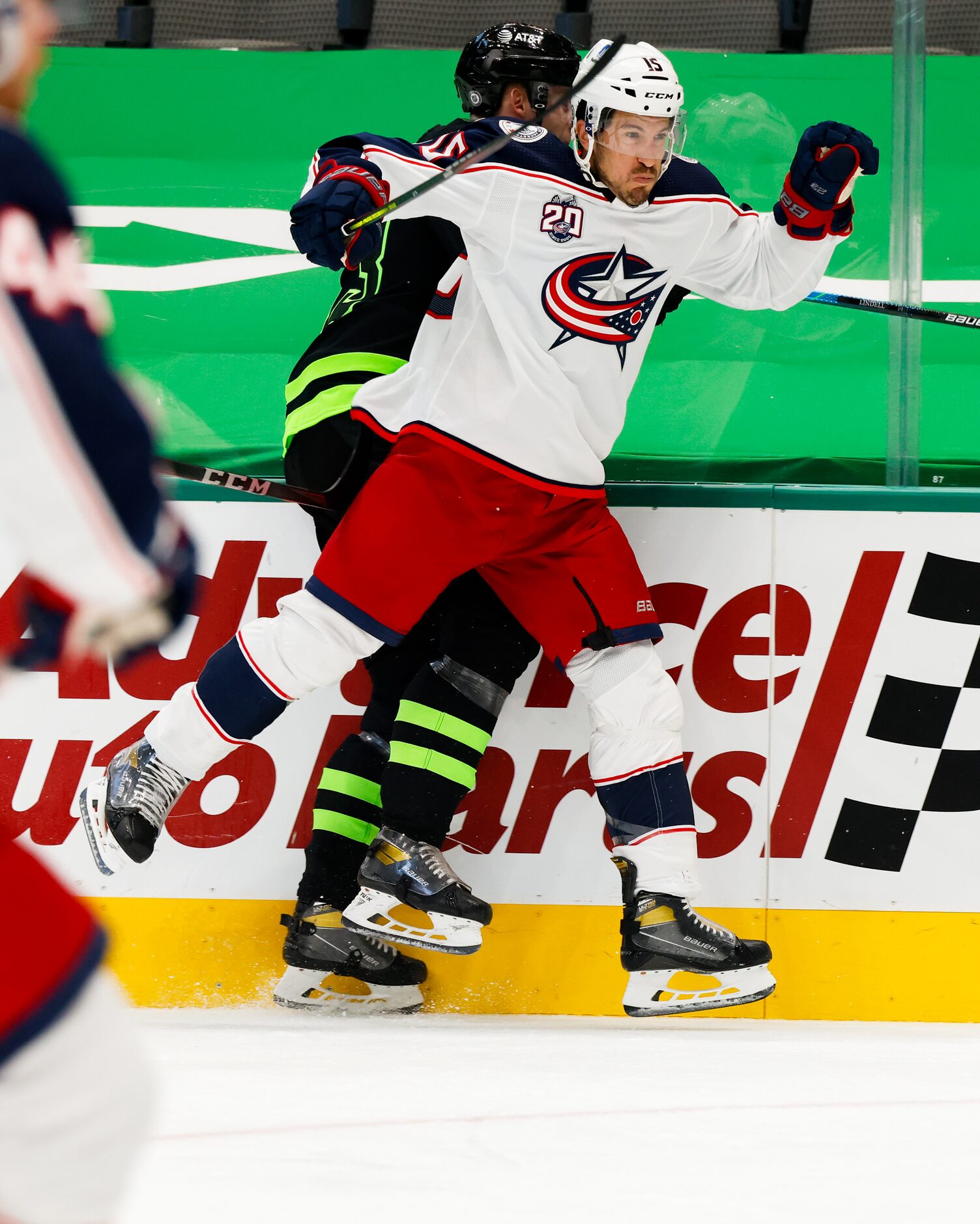 Dallas Stars defenseman Esa Lindell (23) is pinned against the wall by Columbus Blue Jackets...