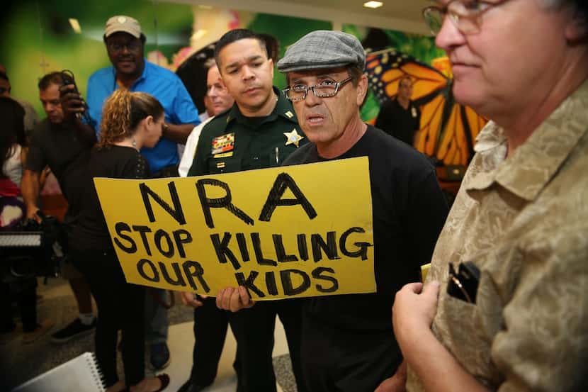 TOPSHOT - People protest against the National Rifle Association at the Broward County Court...
