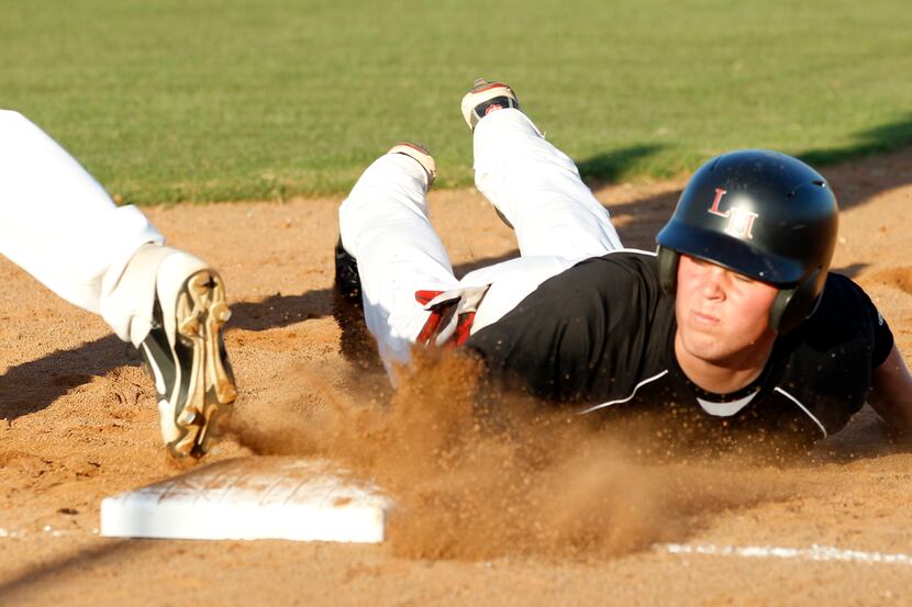 Lake Highland High's Michael Ketchmark (17) slides safely back into first base during a...