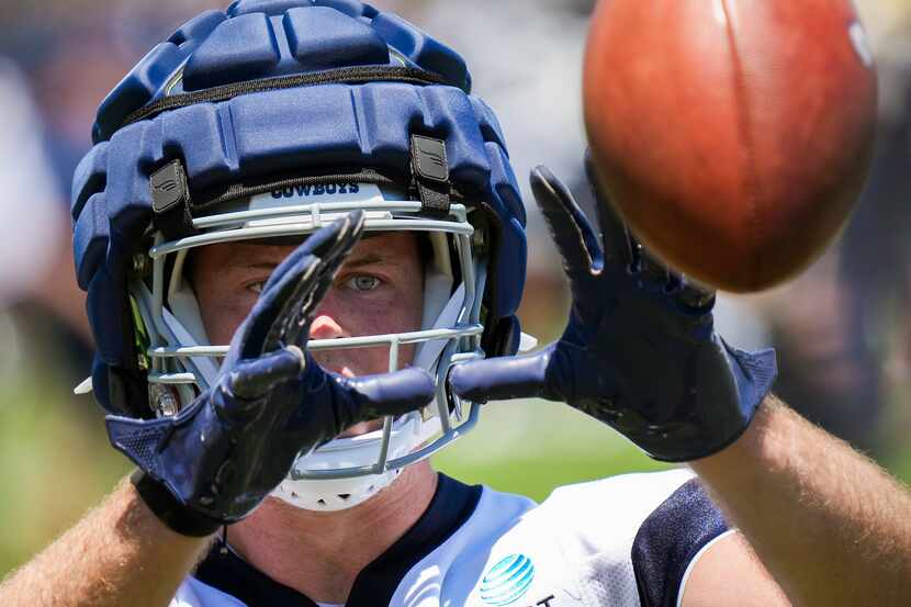 Dallas Cowboys tight end Luke Schoonmaker reaches for a ball during the first practice of...