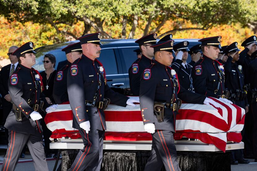 Pall bearers carry the casket of Carrollton police Officer Steve Nothem during his funeral...