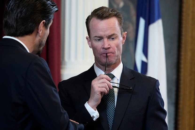 FILE - Texas House Speaker Dade Phelan, right, talks with a fellow lawmaker in the House...