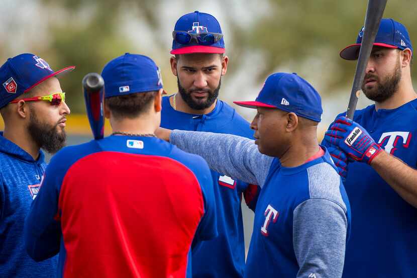 Texas Rangers third base coach Tony Beasley (second from right) works with (from left)...
