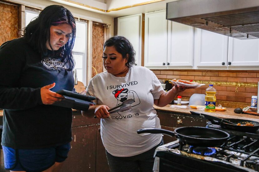 Veloz's sister, 15-year-old Kimberly Veloz, shows her something on an iPad while Veloz...