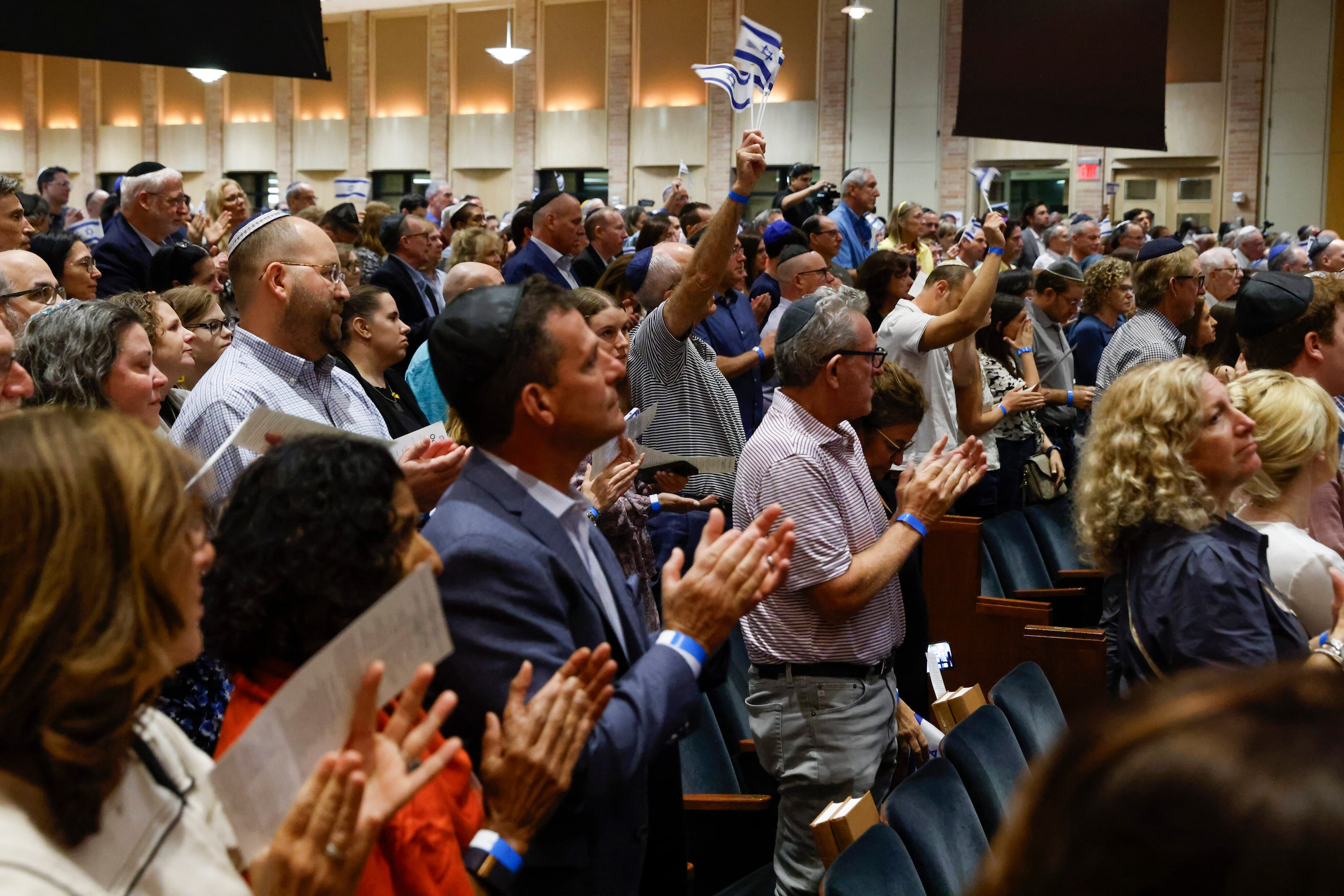 People stand and applaud after listening to a testimony from LeElle Slifer about her cousin...